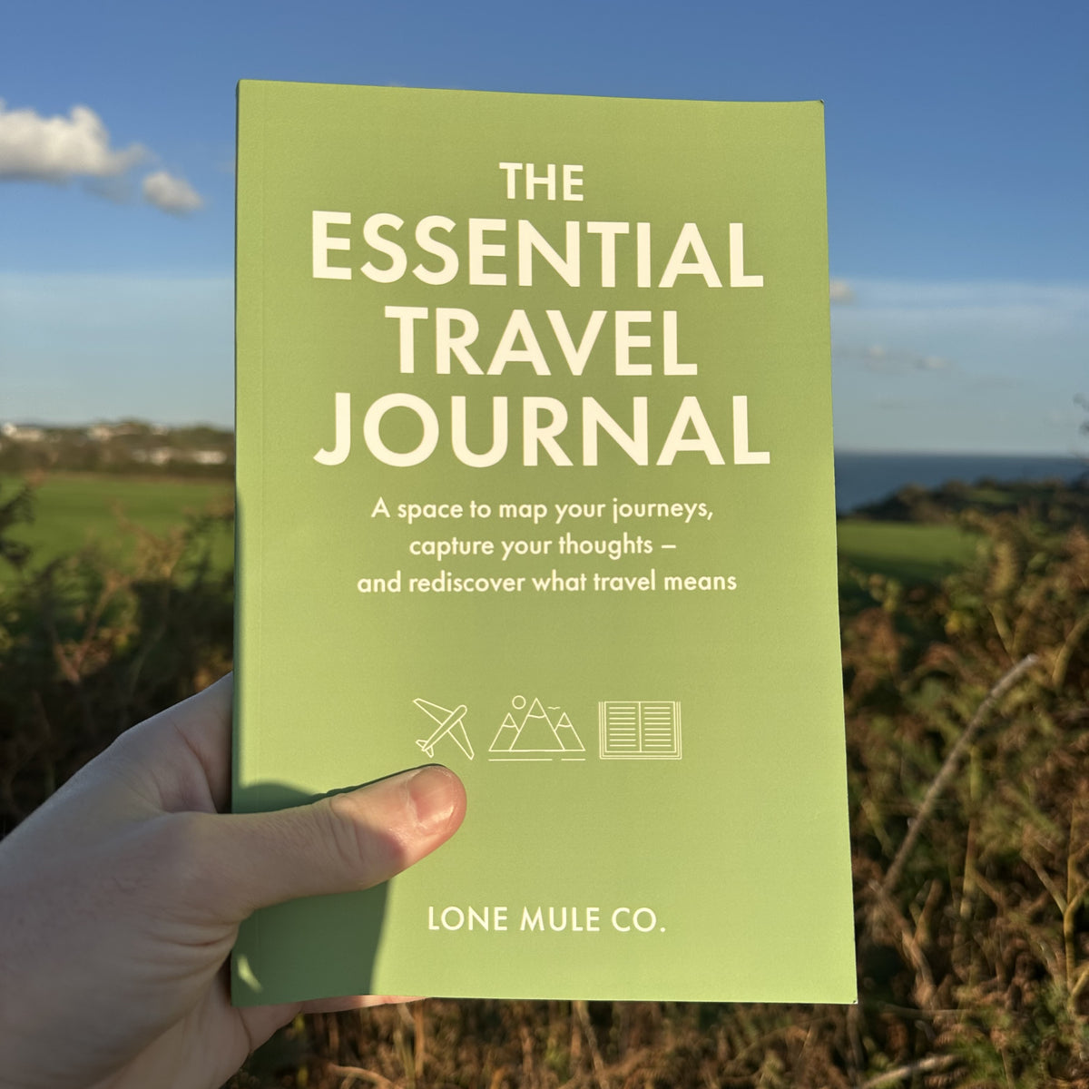 Sage Green & White Essential Travel Journal by Lone Mule Co. shown as a physical paperback copy.